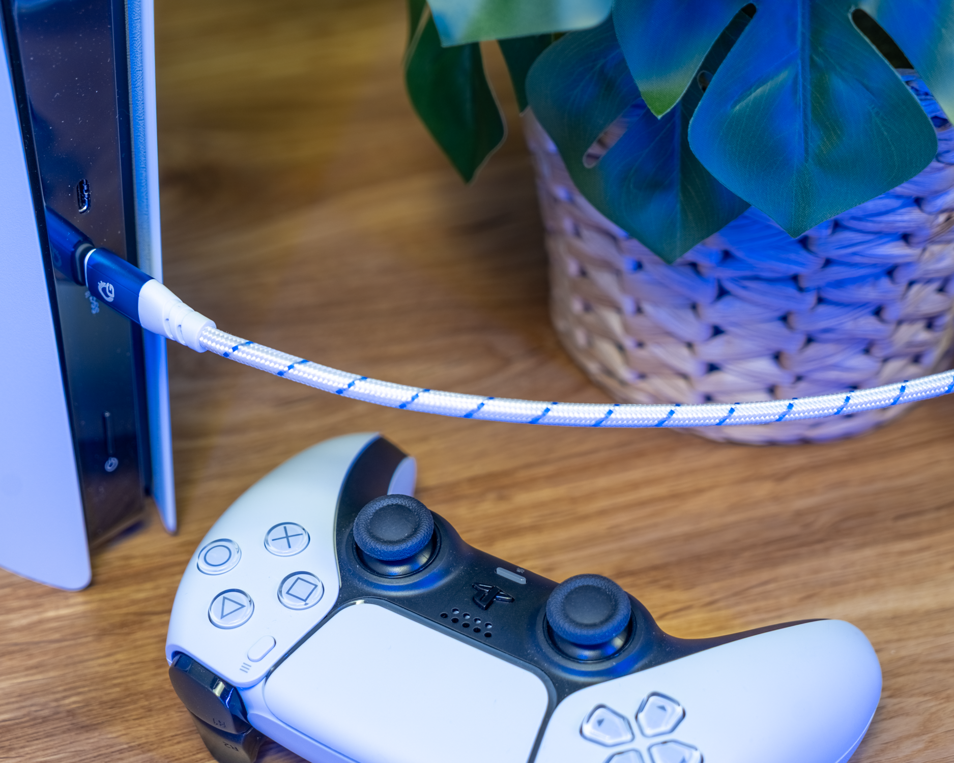 Konsole links mit blauem Kabel, Controller unscharf im Vordergrund