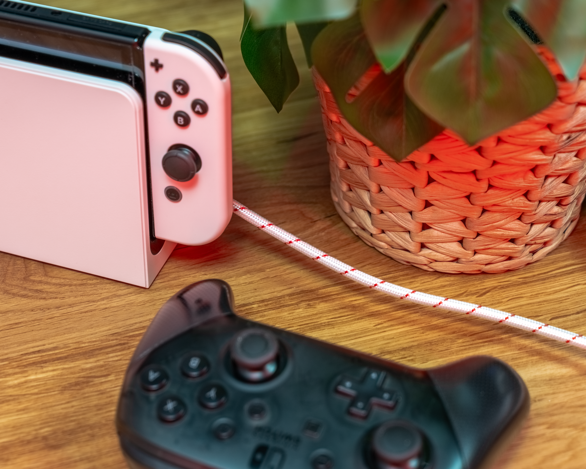 New Game Red AC Konsole links mit rotem Kabel, Controller unscharf im Vordergrund