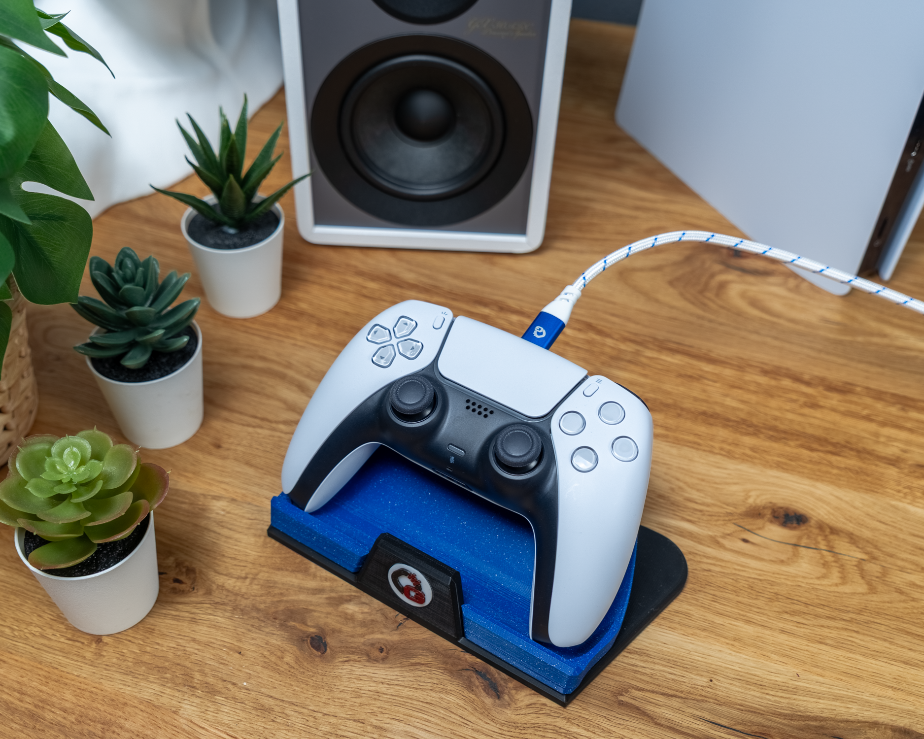 Gamecontroller rechts auf Ladestation, verbunden mit weiß-blauem Kabel
