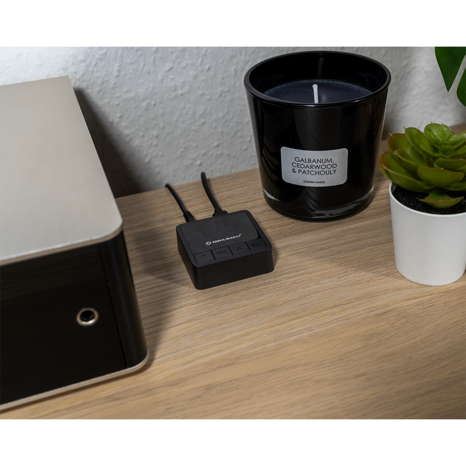 Bluetooth Transmitter Receiver Oehlbach mit schwarz-silbernem Gehäuse und LED-Anzeige vorne - zwei Kabel seitlich angeschlossen