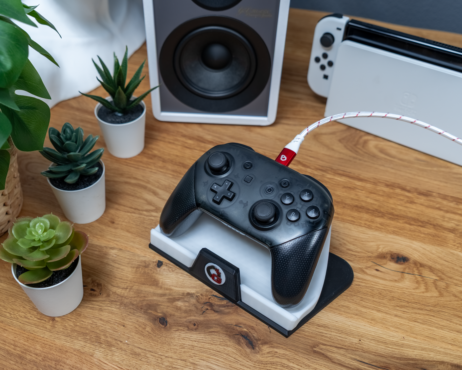 Gamecontroller rechts auf Ladestation, verbunden mit rot-weißem Kabel