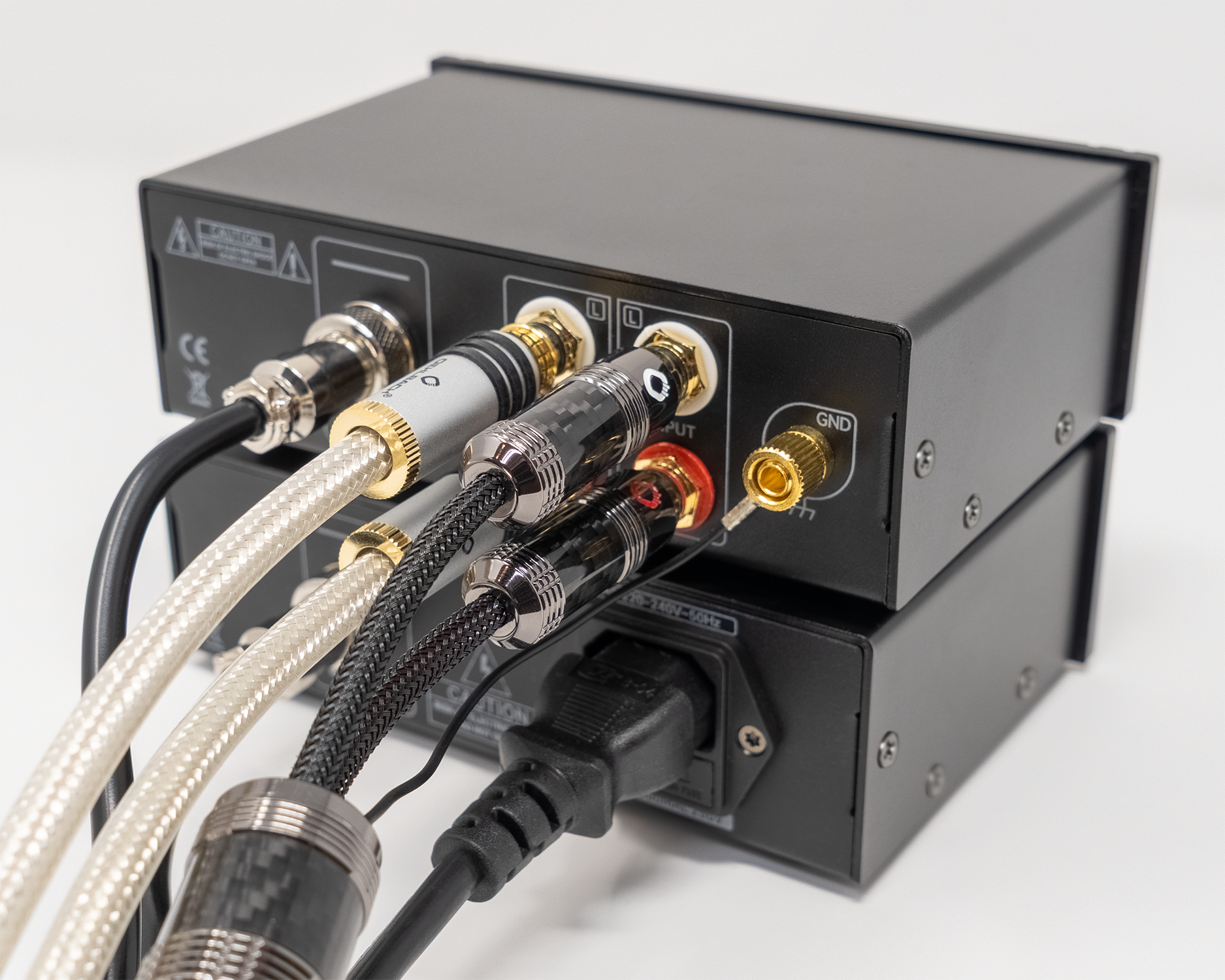 Rückseite gestapelter Oehlbach-Geräte mit angeschlossenen RCA-Kabeln und Netzkabel