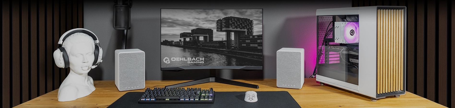 Kategorie Bild Monitor mit Oehlbach-Gaming-Logo zwischen zwei Lautsprechern, rechts PC mit pinker Beleuchtung