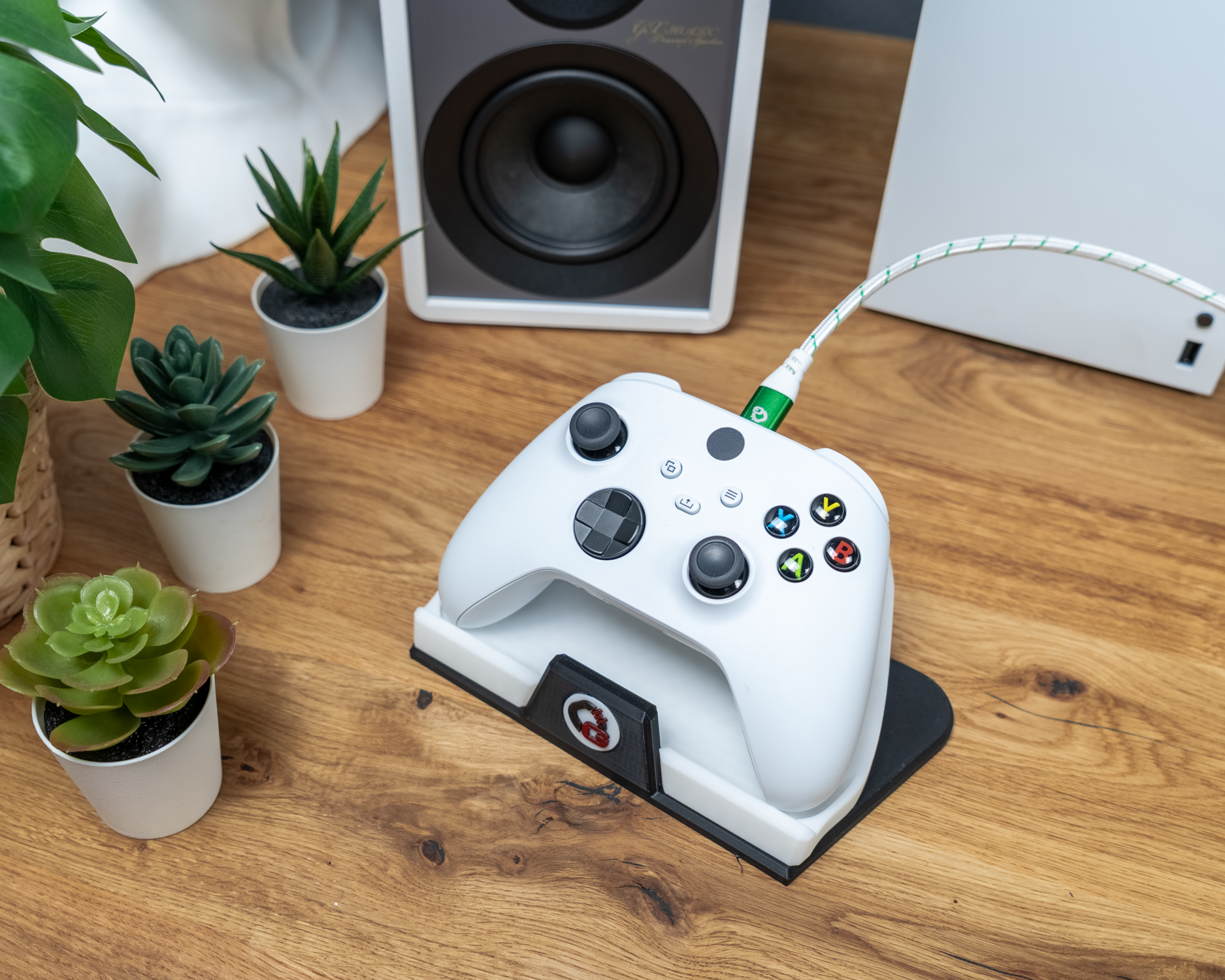 Gamecontroller rechts auf Ladestation, verbunden mit weiß-grünem Kabel