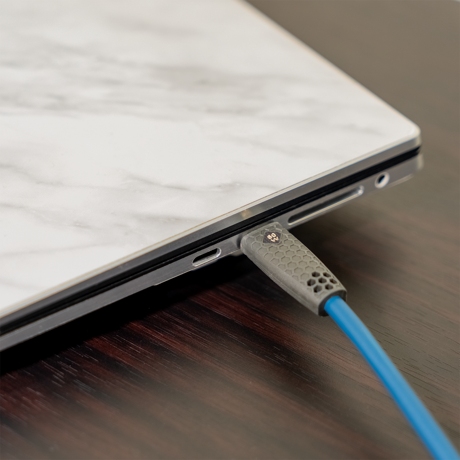 USB-C-Kabel an Laptop mit weißer Marmoroptik angeschlossen