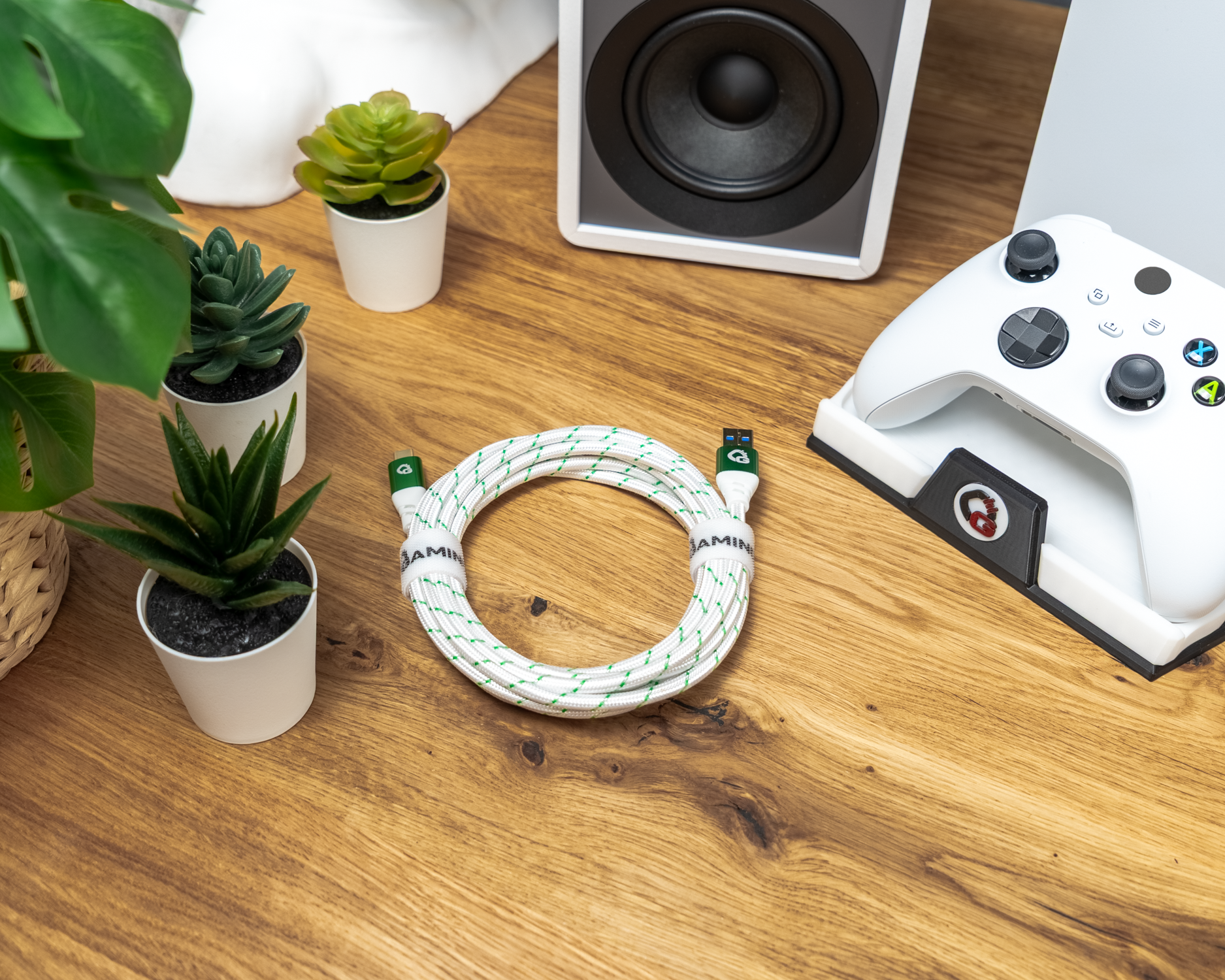 Aufgerolltes grün-weißes Kabel mit Gaming-Aufdruck auf Holztisch